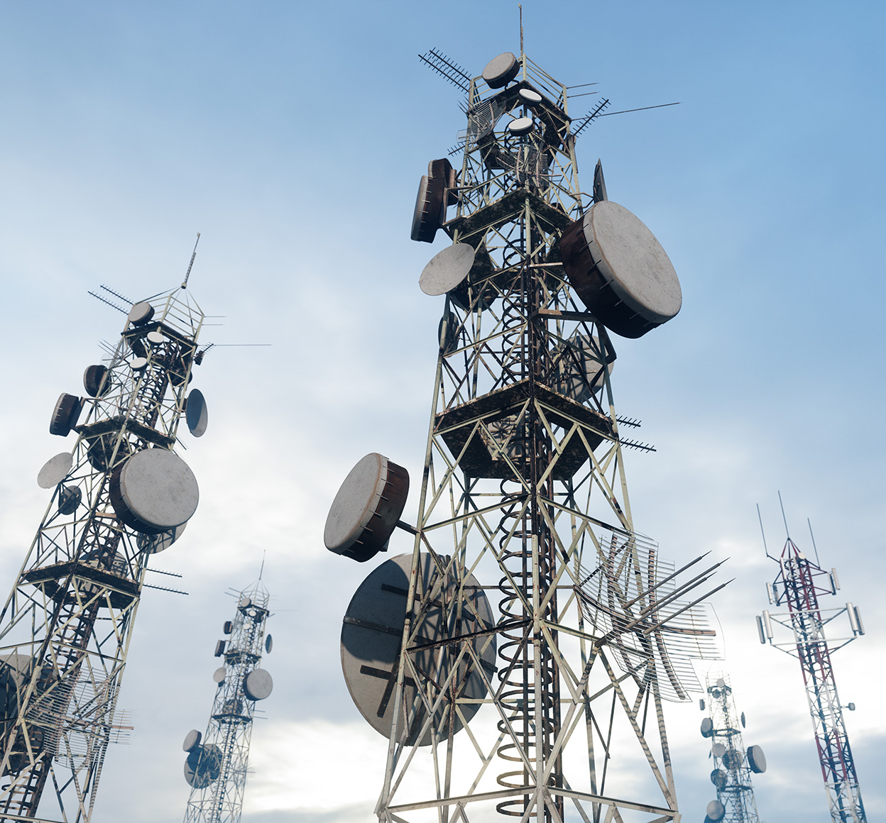 A close-up of antenna towers, their geometric shapes stark against the blue sky.